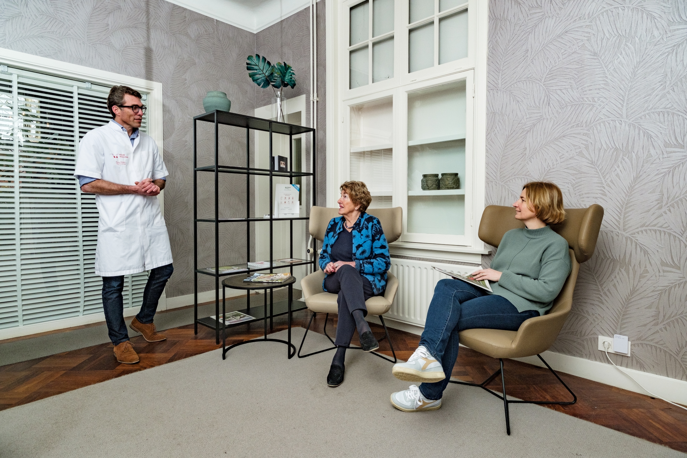 Chirurg verwelkomt een patiënt in de wachtkamer van de kliniek